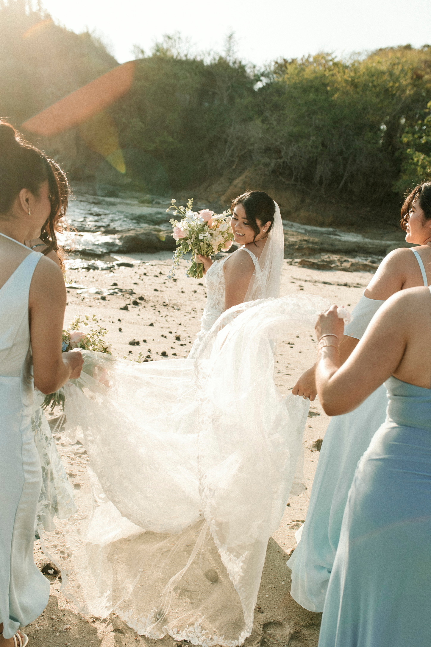 Bride with her bouquet and bridesmaids on the beach
