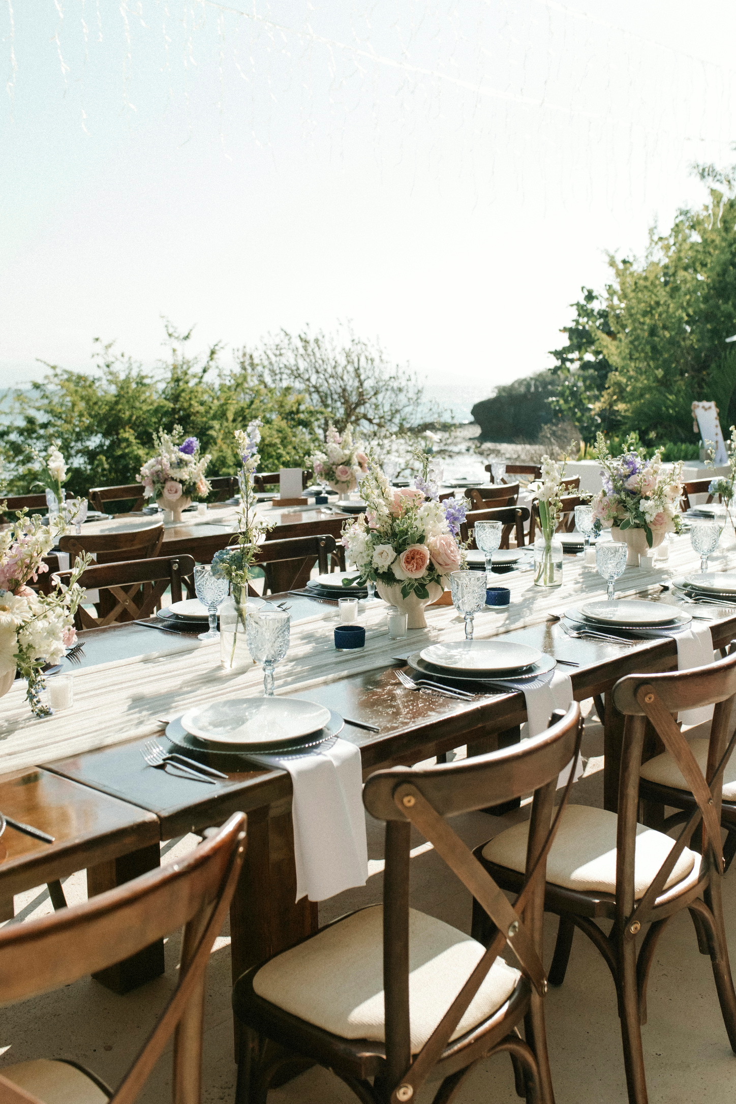 Long table set for an outdoor wedding dinner
